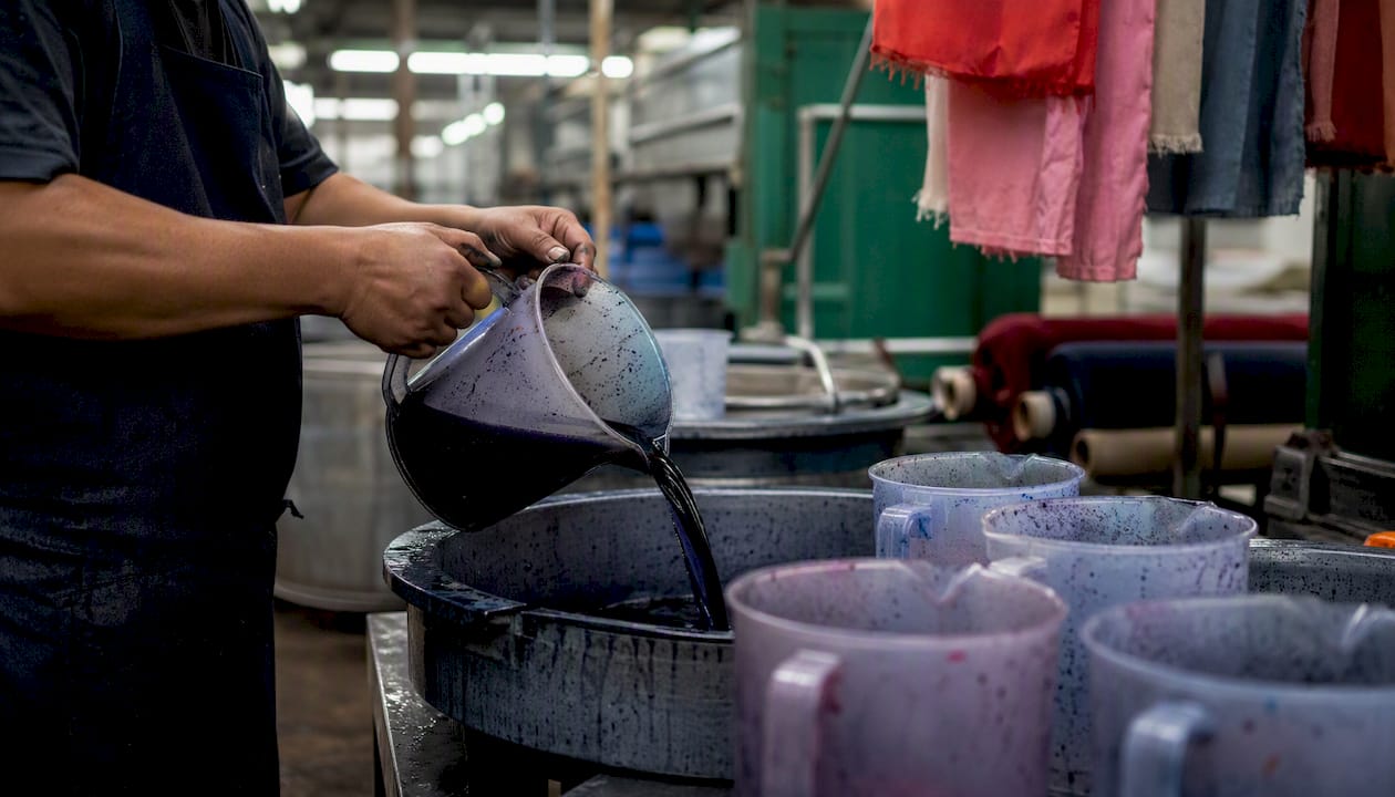 Personal manipulando y preparando tintes en el área de producción textil
